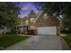 Brick home at twilight with a manicured lawn, attached garage, and a welcoming front porch at 4 Pickard Pl, Durham, NC 27703