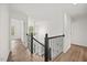 Bright hallway with wood floors, black railing, and an elegant hanging light fixture at 4 Pickard Pl, Durham, NC 27703