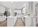 Updated kitchen showcasing white cabinets, a spacious center island with a cooktop, and stainless steel appliances at 4 Pickard Pl, Durham, NC 27703