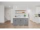 Close-up of kitchen wet bar featuring floating shelves, a tile backsplash and grey cabinets at 4 Pickard Pl, Durham, NC 27703