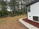 A beautiful backyard space with a cement walk way, mulch beds, and wooded area at 401 Commonwealth St, Durham, NC 27703