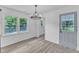 Bright dining area features a modern chandelier, wood flooring, and large windows at 460 Bunn Elementary School Rd, Bunn, NC 27508