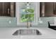 Bright kitchen features modern countertops, backsplash, and a stainless steel sink overlooking the backyard at 460 Bunn Elementary School Rd, Bunn, NC 27508