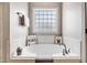 Bright bathroom featuring a soaking tub with tile surround and a window for natural light at 479 Manchester Trail, Clayton, NC 27527