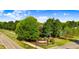 Attractive community entrance with brick signage, manicured landscaping, and a lush canopy of mature trees at 479 Manchester Trail, Clayton, NC 27527