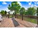 Outdoor deck with wood flooring and dark brown railing, offering tranquil views of the backyard at 479 Manchester Trail, Clayton, NC 27527