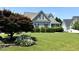 Charming home featuring a well-manicured lawn and vibrant landscaping including flowering plants and trimmed hedges at 479 Manchester Trail, Clayton, NC 27527