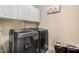 Laundry room with front loading washer and dryer with white cabinets for storage at 479 Manchester Trail, Clayton, NC 27527