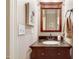 Chic powder room with dark wood vanity, granite countertop, and decorative mirror at 479 Manchester Trail, Clayton, NC 27527