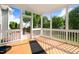 Relaxing screened-in porch featuring wood flooring and views of the backyard and green trees at 479 Manchester Trail, Clayton, NC 27527