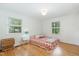 Simple bedroom with hardwood floors, two windows, and a cozy bed for comfortable sleeping at 4808 Berini Dr, Durham, NC 27705