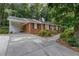Classic brick home with an attached carport and a walkway through landscaped shrubs to the front entrance at 4808 Berini Dr, Durham, NC 27705
