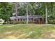 Charming single-story brick home featuring black shutters, mature landscaping, and a well-manicured lawn at 4808 Berini Dr, Durham, NC 27705