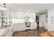 Well-lit kitchen boasting white cabinets, granite countertops, stainless steel range, and herringbone flooring at 4808 Berini Dr, Durham, NC 27705