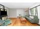 Bright living room featuring hardwood floors, neutral walls, and green furniture at 4808 Berini Dr, Durham, NC 27705