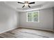 Bedroom featuring wood floors, a tray ceiling, a ceiling fan, and a window with natural light at 520 Kenton Mill Ct, Rolesville, NC 27571