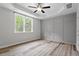 Bright bedroom featuring wood floors, tray ceilings, a ceiling fan, and abundant natural light at 520 Kenton Mill Ct, Rolesville, NC 27571