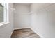 Empty walk in closet with built in shelving and wood flooring at 520 Kenton Mill Ct, Rolesville, NC 27571