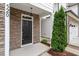 Close-up of front door with stone facade, black door, manicured landscaping and walkway at 520 Kenton Mill Ct, Rolesville, NC 27571