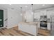 Modern kitchen with island, granite countertops, stainless appliances, and decorative accent wall at 520 Kenton Mill Ct, Rolesville, NC 27571