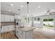 Bright kitchen features island with granite countertops, stainless appliances, and sliding glass door to backyard at 520 Kenton Mill Ct, Rolesville, NC 27571