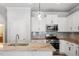 Bright kitchen featuring granite countertops, stainless steel appliances, and a stylish backsplash at 520 Kenton Mill Ct, Rolesville, NC 27571