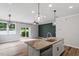 Open concept kitchen with stylish island, stainless appliances, backyard view, and modern pendant lighting at 520 Kenton Mill Ct, Rolesville, NC 27571