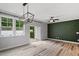 Living room with wood floors, stylish green accent wall, modern lighting, and sliding door to patio at 520 Kenton Mill Ct, Rolesville, NC 27571