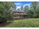 Rear exterior view of a two-story home, complete with a screened porch, and a wooden deck overlooking the lawn at 522 N Scotswood Blvd, Hillsborough, NC 27278