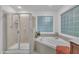 Bright bathroom features a tub with tile surround and a glass block window for natural light at 522 N Scotswood Blvd, Hillsborough, NC 27278