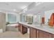 Luxurious bathroom showcasing a soaking tub, glass block window, and double sink vanity with ample counter space at 522 N Scotswood Blvd, Hillsborough, NC 27278