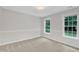 A light-filled bedroom features neutral carpet, fresh paint, and a lovely window view at 522 N Scotswood Blvd, Hillsborough, NC 27278