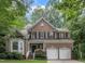 Charming brick home featuring a manicured lawn, attached two-car garage, and lush landscaping at 522 N Scotswood Blvd, Hillsborough, NC 27278