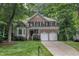Traditional two-story brick home featuring a manicured lawn, attached two-car garage, and mature trees at 522 N Scotswood Blvd, Hillsborough, NC 27278