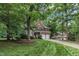 Beautiful home with a long driveway and lush green lawn surrounded by mature trees at 522 N Scotswood Blvd, Hillsborough, NC 27278