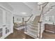 Spacious foyer featuring hardwood floors, staircase, and view into the living room with abundant natural light at 522 N Scotswood Blvd, Hillsborough, NC 27278