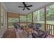 Screened in porch with an outdoor ceiling fan, wicker chairs, and privacy shades at 522 N Scotswood Blvd, Hillsborough, NC 27278