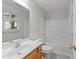 Bathroom with a tub shower, decorative vinyl flooring, and a large vanity mirror at 5506 Cottonrose Ln, Raleigh, NC 27606