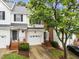 Attractive townhouse with a white exterior, black shutters, and a well-manicured front yard at 5506 Cottonrose Ln, Raleigh, NC 27606