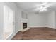Cozy living room featuring dark wood flooring, a ceiling fan, and a fireplace with a decorative mantle at 5506 Cottonrose Ln, Raleigh, NC 27606