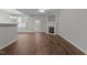 Open-concept living room with dark wood floors, a fireplace, and a door to the backyard at 5506 Cottonrose Ln, Raleigh, NC 27606
