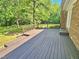 Large wooden deck adjacent to a brick home overlooking a green yard at 5614 Skyline Dr, Durham, NC 27712