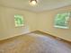 Comfortable bedroom featuring two windows that offer natural light, and neutral carpeting at 5614 Skyline Dr, Durham, NC 27712