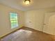 A bright bedroom with a window providing natural light and a closet for storage at 5614 Skyline Dr, Durham, NC 27712