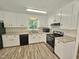Modern kitchen featuring white cabinets, black appliances, and spacious countertops at 5614 Skyline Dr, Durham, NC 27712