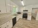 Well-lit kitchen with white cabinets, granite countertops, and updated appliances at 5614 Skyline Dr, Durham, NC 27712