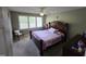 Bedroom with a bed, window with a chair, and neutral-toned walls at 5810 Stardust Ct, Durham, NC 27712
