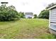 Sprawling backyard with a partial view of the house and surrounding trees at 601 Country Ln, Holly Springs, NC 27540