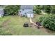 Large backyard with mature trees, fire pit area, and outdoor seating at 601 Country Ln, Holly Springs, NC 27540