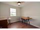 Cozy bedroom featuring a ceiling fan, a window, and a vintage sewing machine at 601 Country Ln, Holly Springs, NC 27540